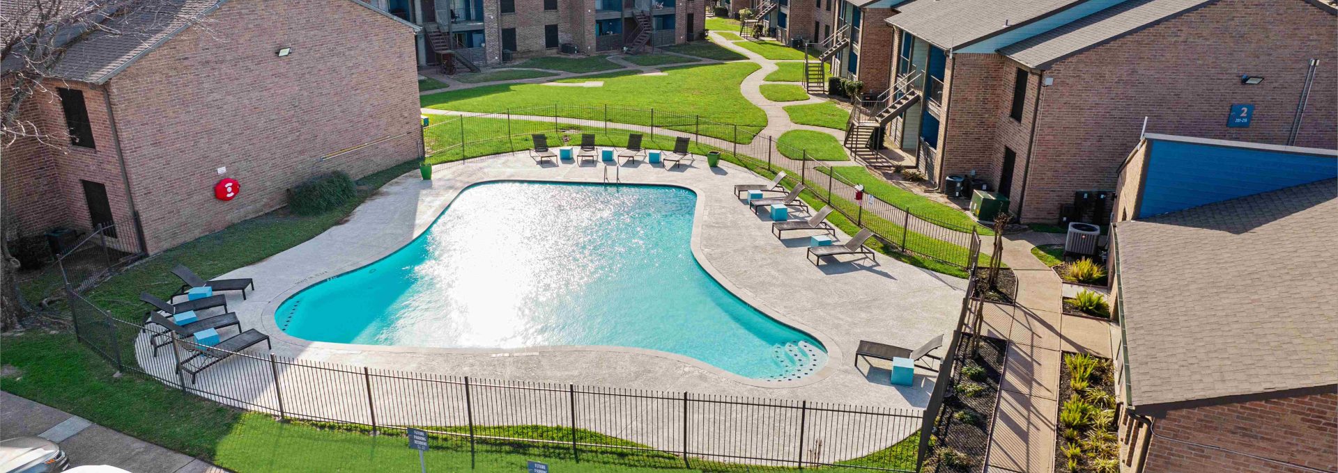 an aerial view of a pool and parking lot at an apartment complex at The Sonoma Apartments