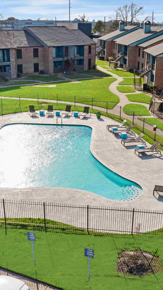 an aerial view of a pool and parking lot at an apartment complex at The Sonoma Apartments